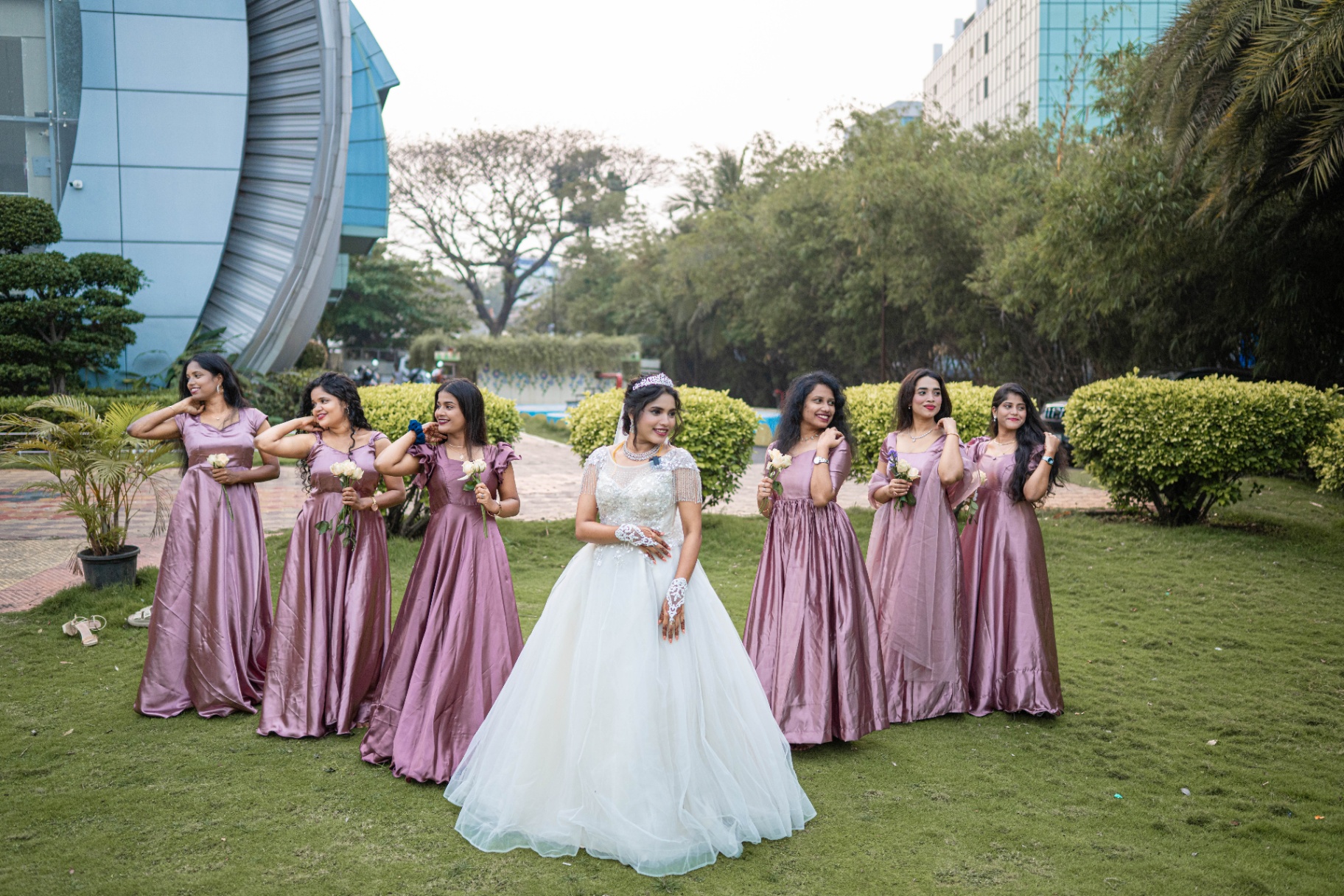 Christian bride in a white gown with her bridesmaids in mauve dresses