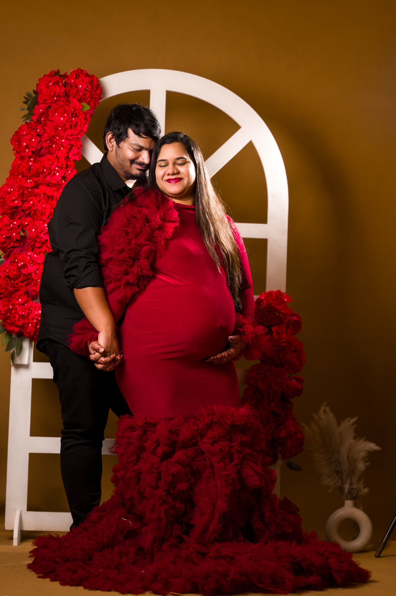Expecting couple in a studio maternity portrait