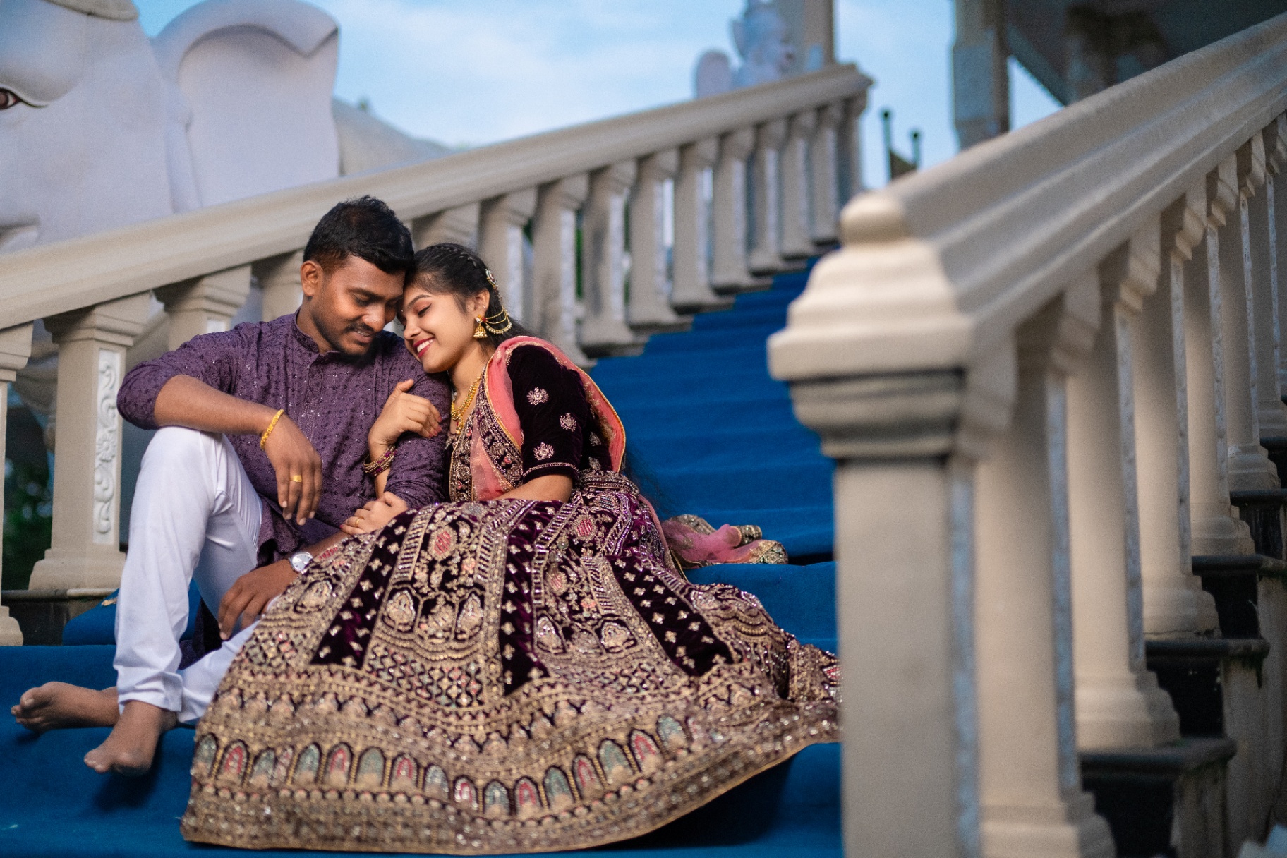 Couple portrait seated on blue palace steps before their wedding