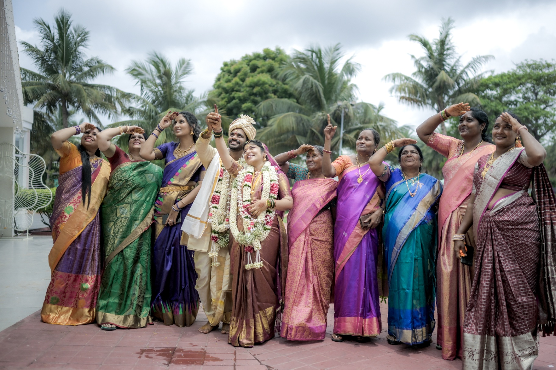 South Indian bride and groom celebrating with women in silk sarees